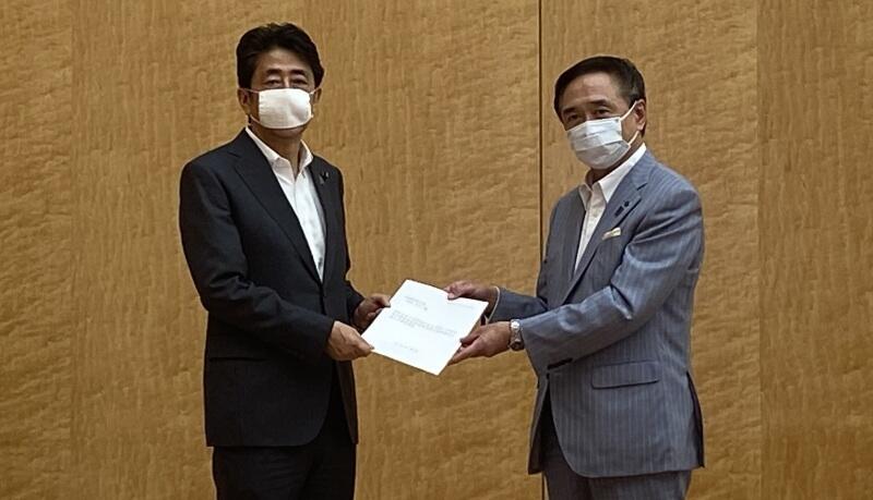 黒岩委員長（神奈川県知事：右）から安倍内閣総理大臣（左）に要望書を手交する様子